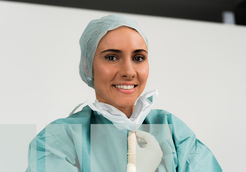 Mitarbeiterin mit OP Haube, Mundschutz und OP-Kittel im OP-Zentrum von OPIW